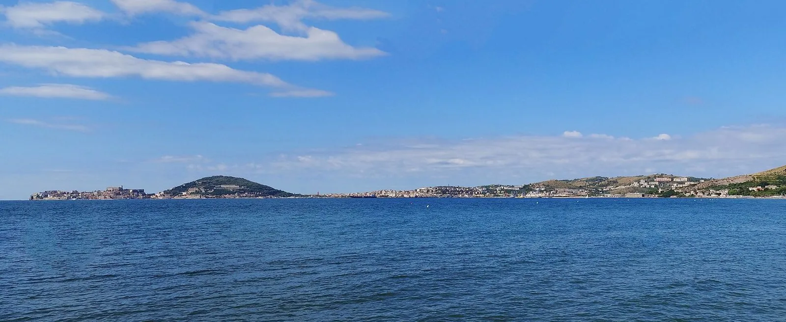 Il golfo di Gaeta in una giornata di sole visto dalla spiaggia di Vindicio a Formia, con il mare blu e il promontorio di Gaeta all'orizzonte