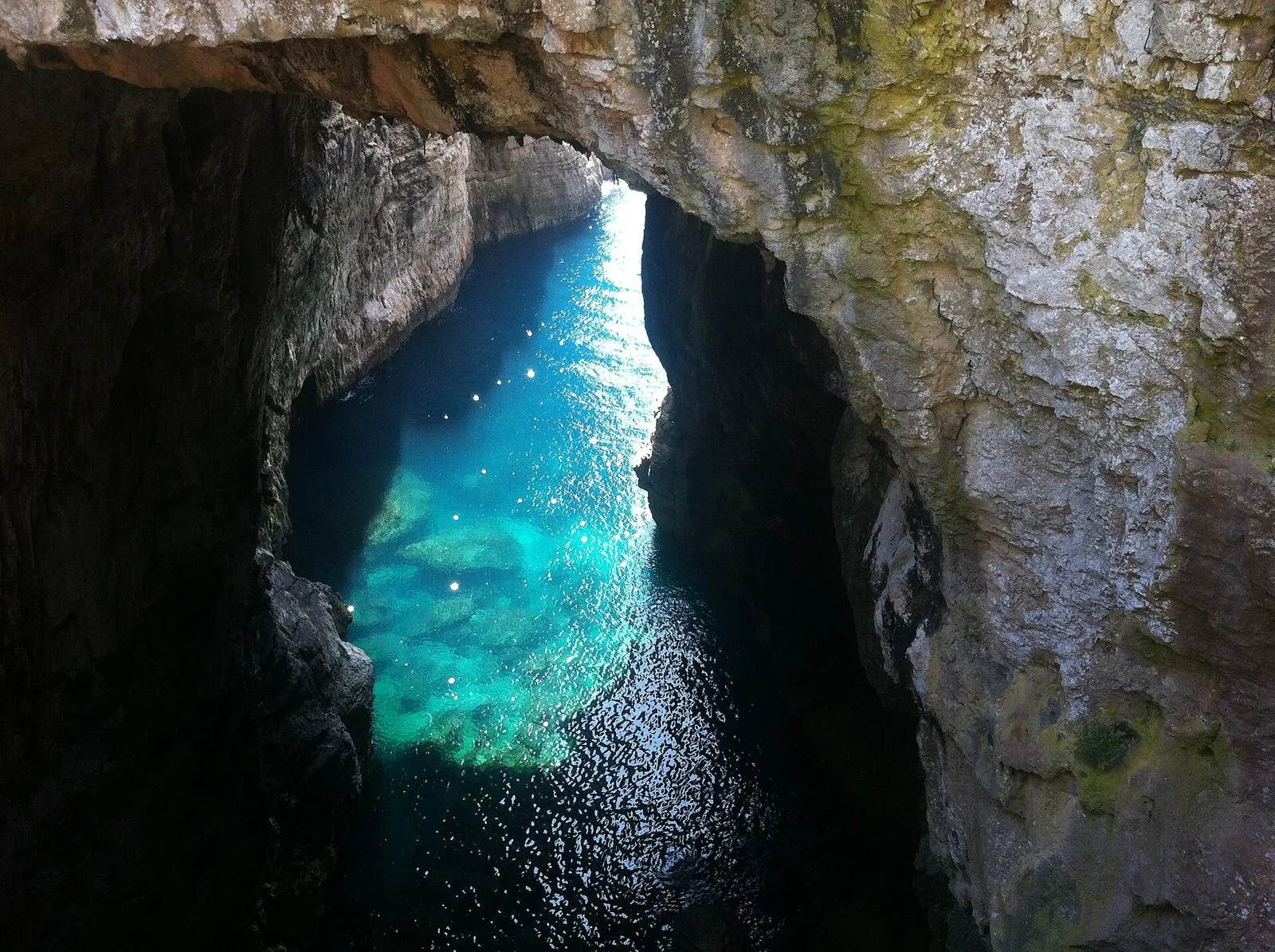 Il mare turchese visto dall'alto all'interno della Grotta del Turco, tra le pareti di roccia di Monte Orlando a Gaeta