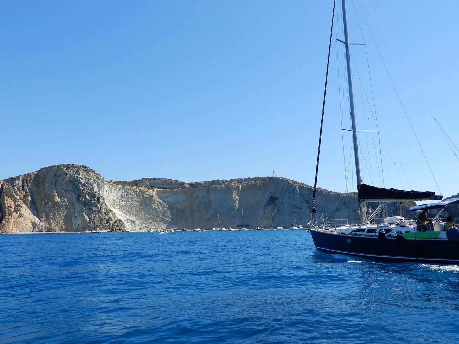 La baia di Chiaia di Luna a Ponza vista dal mare, con l'alta parete di roccia chiara e barche ancorate al largo